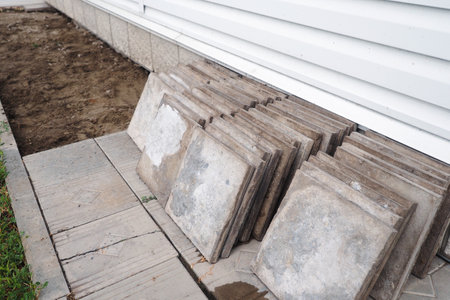 Facing concrete tiles lie on ground in stack. Replacing building foundation. Repair and construction. Background.の写真素材