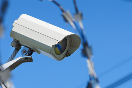 Outdoor surveillance camera against blue sky. View from bottom to top. Object security.の写真素材