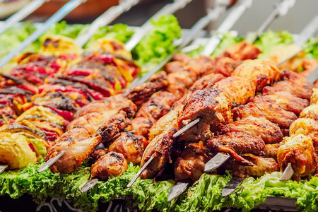 Shashlik. Baked meat on skewer with herbs. Delicious healthy lunch. Closeup of grilled meat on fire.の写真素材