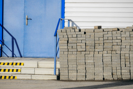 Stack of paving slabs in front of a blue garage door.の写真素材