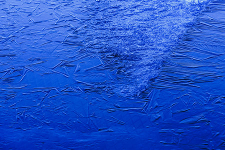 Ice patterns on a lake frozen as an abstract background. Texture.
