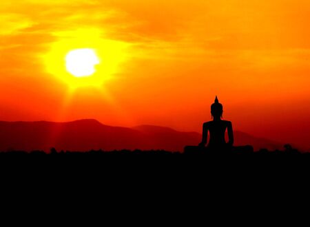 buddha silhouette  on mountain with sunset backgroundの写真素材