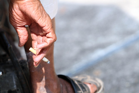 Older man holds cigaretteの写真素材