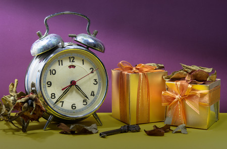 Still life with broken alarm clock, vintage key, dead rose, gift boxs, colorful background.の写真素材