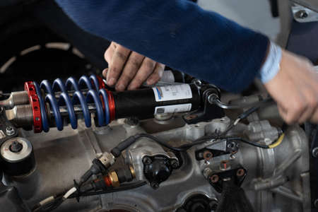 Mechanic working on race car suspension. Moving hands. Selective focus.の写真素材
