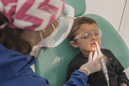A child with a dentist in a dental office. Dental treatment in a children's clinic.