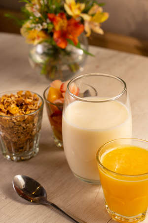 Healthy breakfast with yogurt, granola, fruits and orange juice.