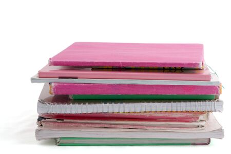 pile of schoolbooks in pink and light green paper isolated on white background