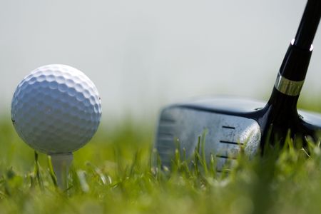 Driver club and white golf ball on small tee. Ready to swingの写真素材