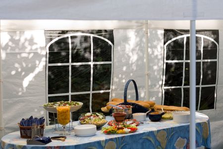 Table filled with salads, sauces and french baguettes