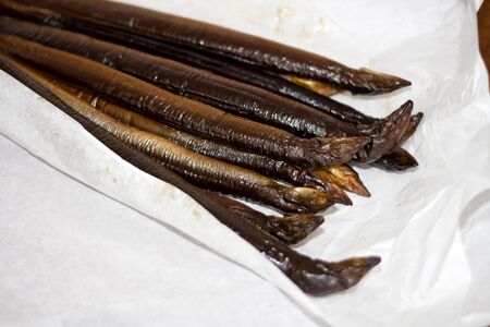 Two pounds of smoked eel on white paperの写真素材