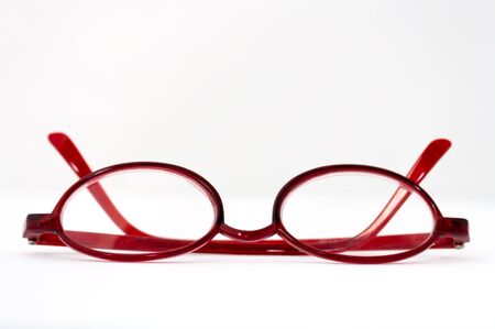 Closed red reading glasses isolated on whiteの写真素材