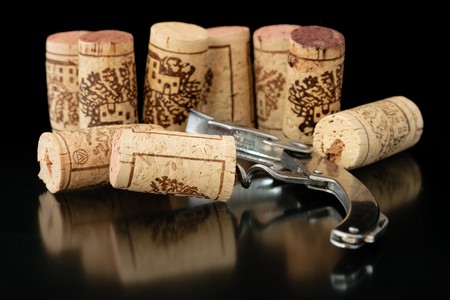 Corkscrew with corks on background
