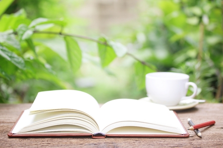 Notebook  and coffee on wooden tableの写真素材