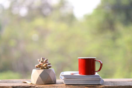Red coffee cup with notebooks and pencil and  modern white plant potの写真素材