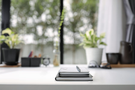 Notebooks with pen white desk decorate with plant pot glasses and others interior designの写真素材