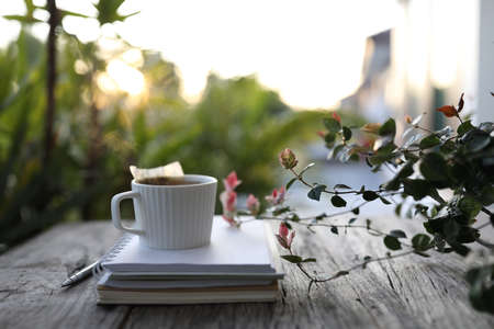 Tea cup with vertical line and plant on wooden table at balcony outdoorの写真素材