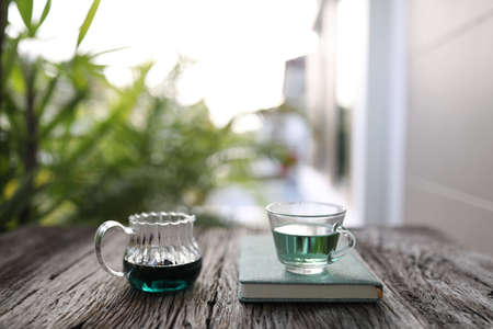 butterfly pea tea and teapot with notebook on grunge tableの写真素材