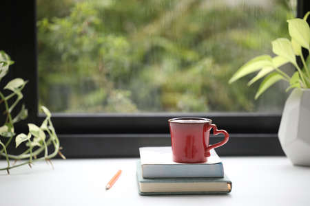 Red coffee cup and notebooks with red pencilの写真素材