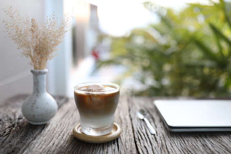 Ice coffee and dry grass flower on wooden tableの写真素材