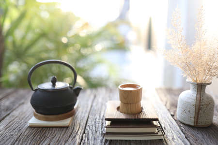 bamboo tea cup and black metal pot with dry grass in a white vaseの写真素材
