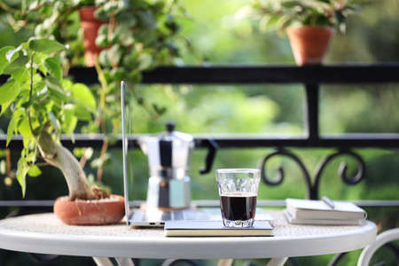 coffee glass cup and moka pot and laptop on metal tableの写真素材