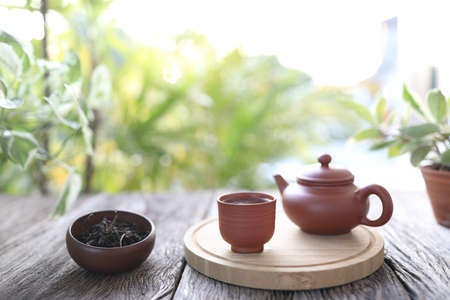 Tea cup and tea pot on wooden trayの写真素材