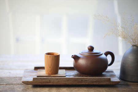 Pottery tea pot and bamboo tea cup on wooden trayの写真素材