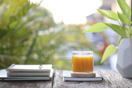 Mango juice and notebooks on wooden tableの写真素材