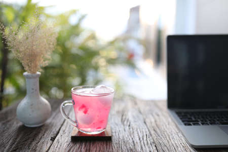strawberry juice and laptop on wooden tableの写真素材