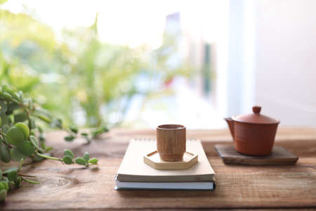 Wooden tea cup and tea pot on wooden tableの写真素材