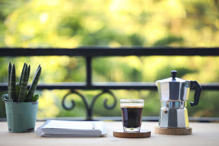 coffee glass cup and moka pot and notebook and Sansevieria pkant on wooden tableの写真素材