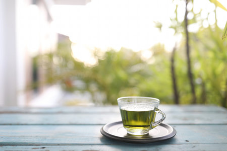 Green tea glass cup on wooden trayの写真素材