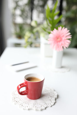 Red coffee cup and Gerbera flowerの写真素材