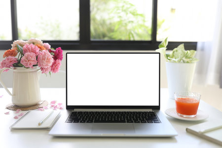 laptop and carrot juice and vase of roses work from home relaxationの写真素材