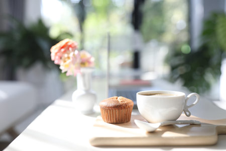 White coffee cup and cupcake and Rose vase on wooden trayの写真素材