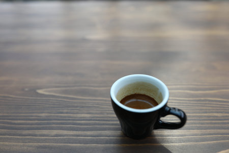 small black coffee cup on wooden tableの写真素材