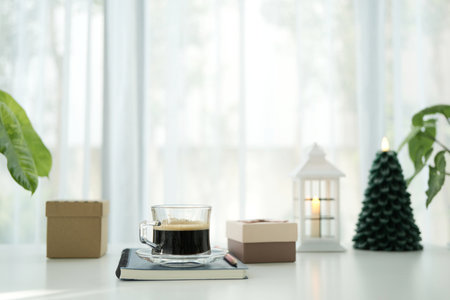 Coffee and notebook with gift box and lantern, small Christmas treeの写真素材