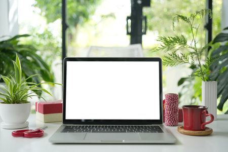 Laptop and red coffee cup with gift box and threadの写真素材