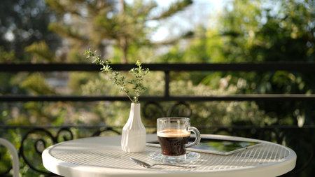 coffee glass cup with notebooks on white metal table outdoor balconyの写真素材