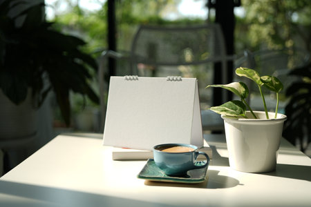 coffee cup and calendar on white table, cozy workspace