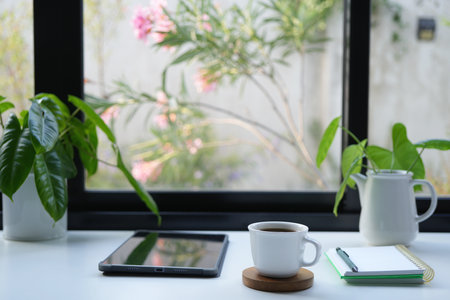 Tablet and coffee drink, cozy indoor work spaceの写真素材