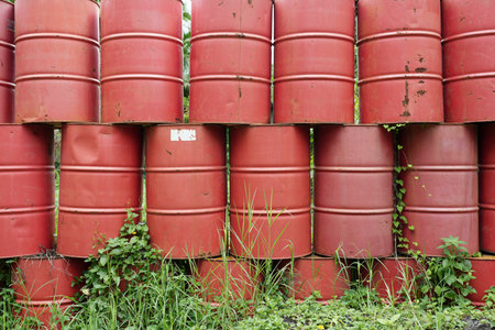 Red barrels lines up in green grass fieldの写真素材
