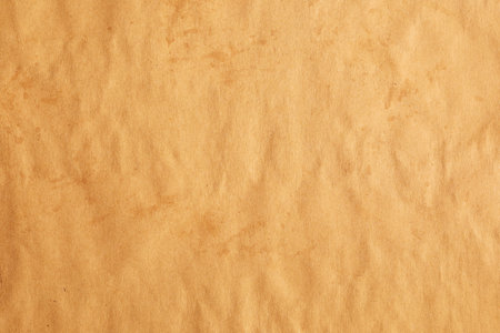 Crumpled kraft brown paper with creases and strainsの写真素材