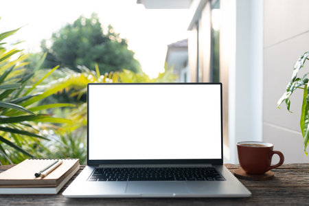 Laptop white screen and stack of notebook and cup, balcony outdoor relaxing viewの写真素材