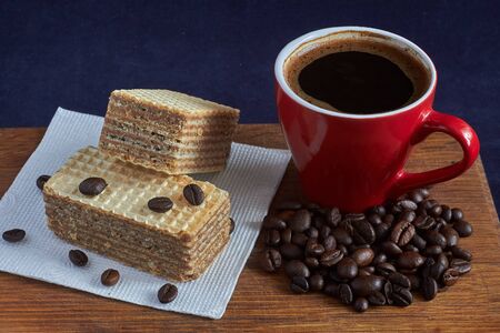 cup of coffee on the board with dessert and coffee beans in natural light