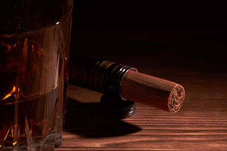 glass of whiskey with cigar on a wooden tableの写真素材