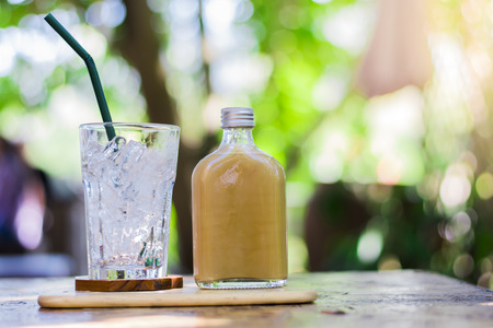 coffee glass bottles and glass have only ice on wood desk