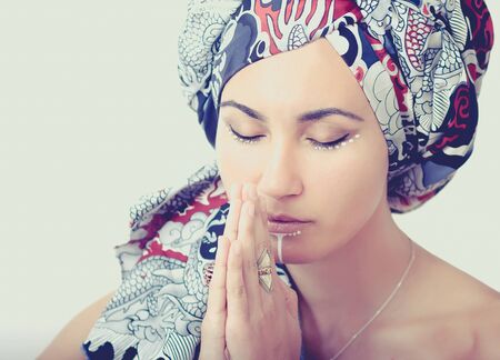 Portrait of praying girl in a turbanの写真素材