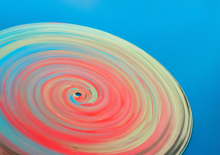 Part of a spiral painted in bright colors vinyl disc on a blue background.